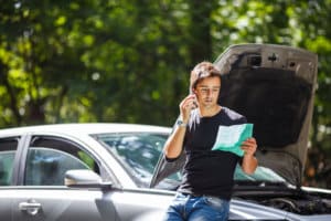 Hombre llamando a su seguro de automóvil para que le entreguen asistencia